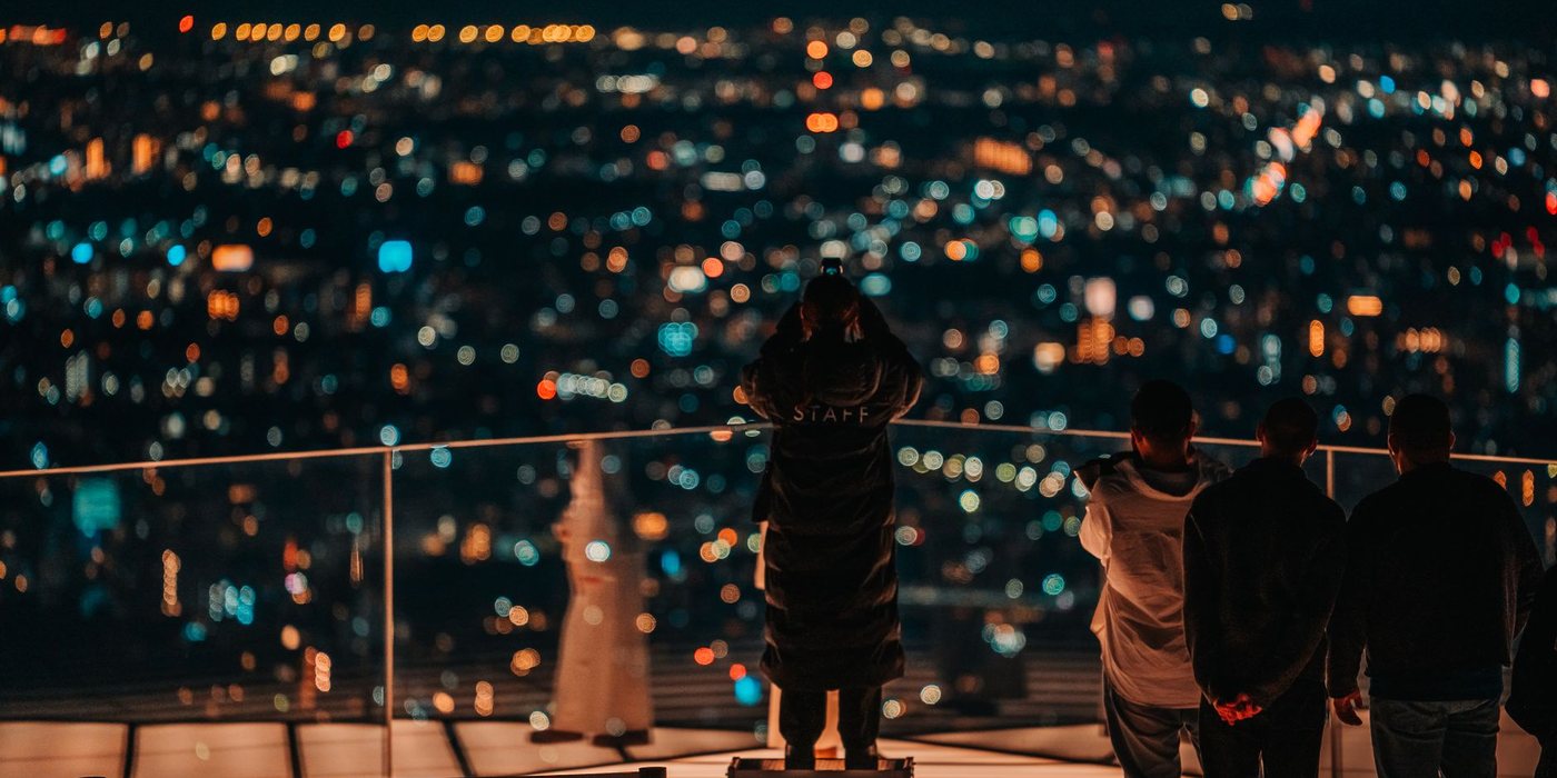Travelers overlooking Tokyo's illuminated skyline